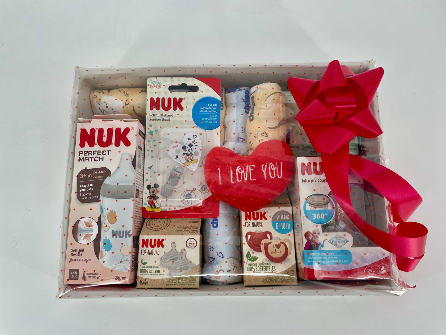 Canastilla de regalo MomentosGourmet para recién nacido con biberones, chupetes NUK y accesorios envueltos en celofán