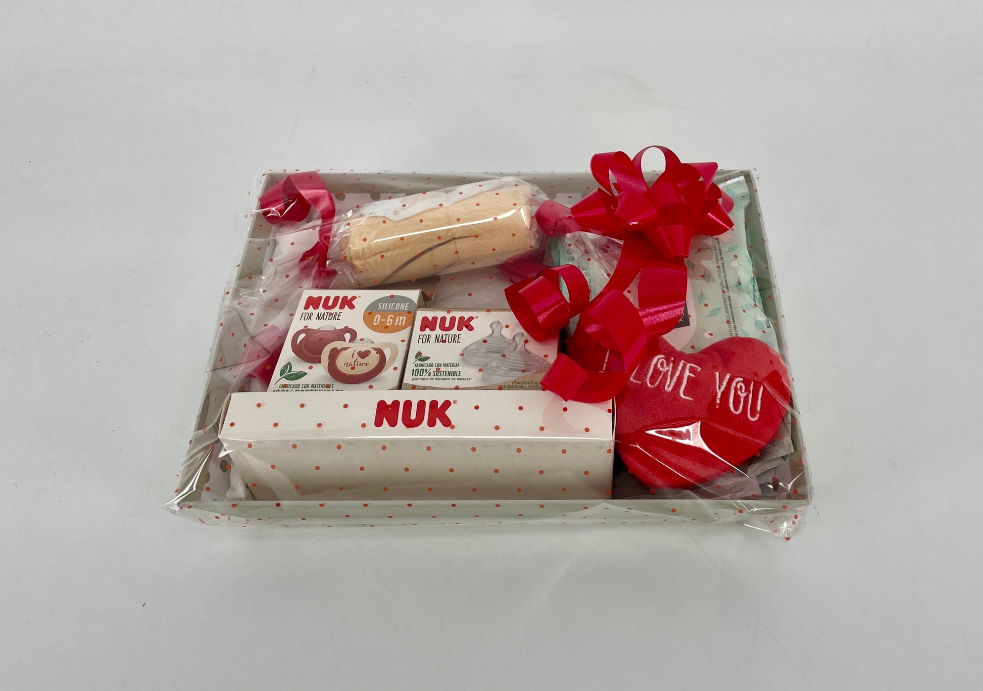 Canastilla de regalo MomentosGourmet para recién nacido con productos NUK, chupetes y corazón decorativo envuelta