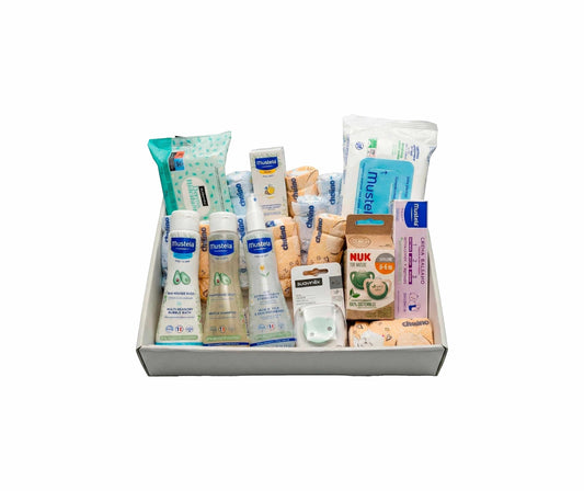 Canastilla MomentosGourmet con productos de aseo Mustela, pañales Chelino, chupete Suavinex y accesorios para bebé.