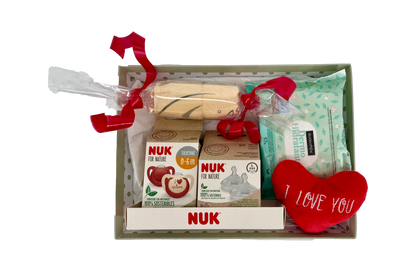 Canastilla de regalo MomentosGourmet con productos NUK para recién nacido, incluyendo chupete, tetinas y toallitas.