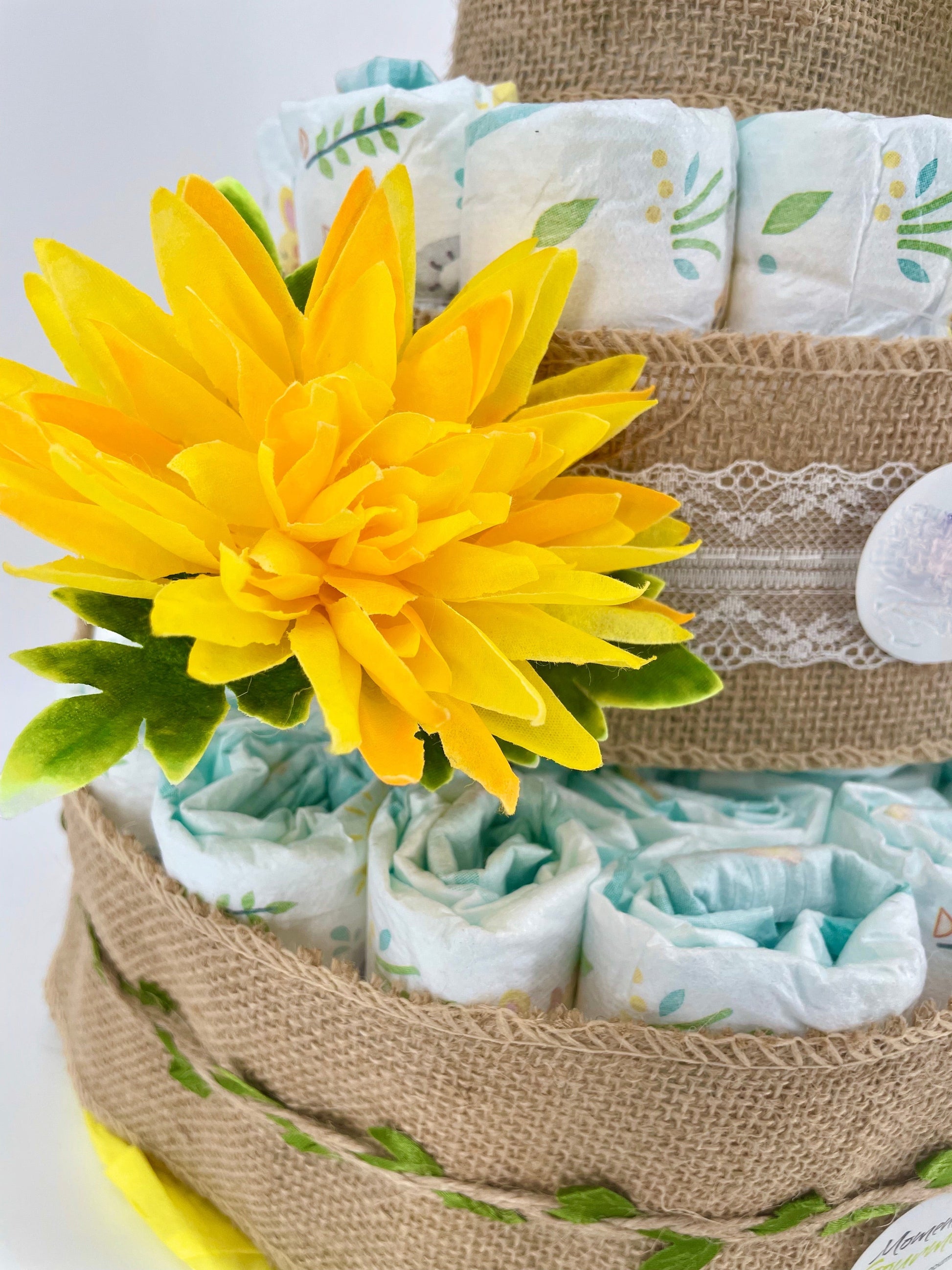 Tarta de pañales Summer de MomentosGourmet decorada con flor amarilla, cinta de arpillera y encaje para regalo de bebé