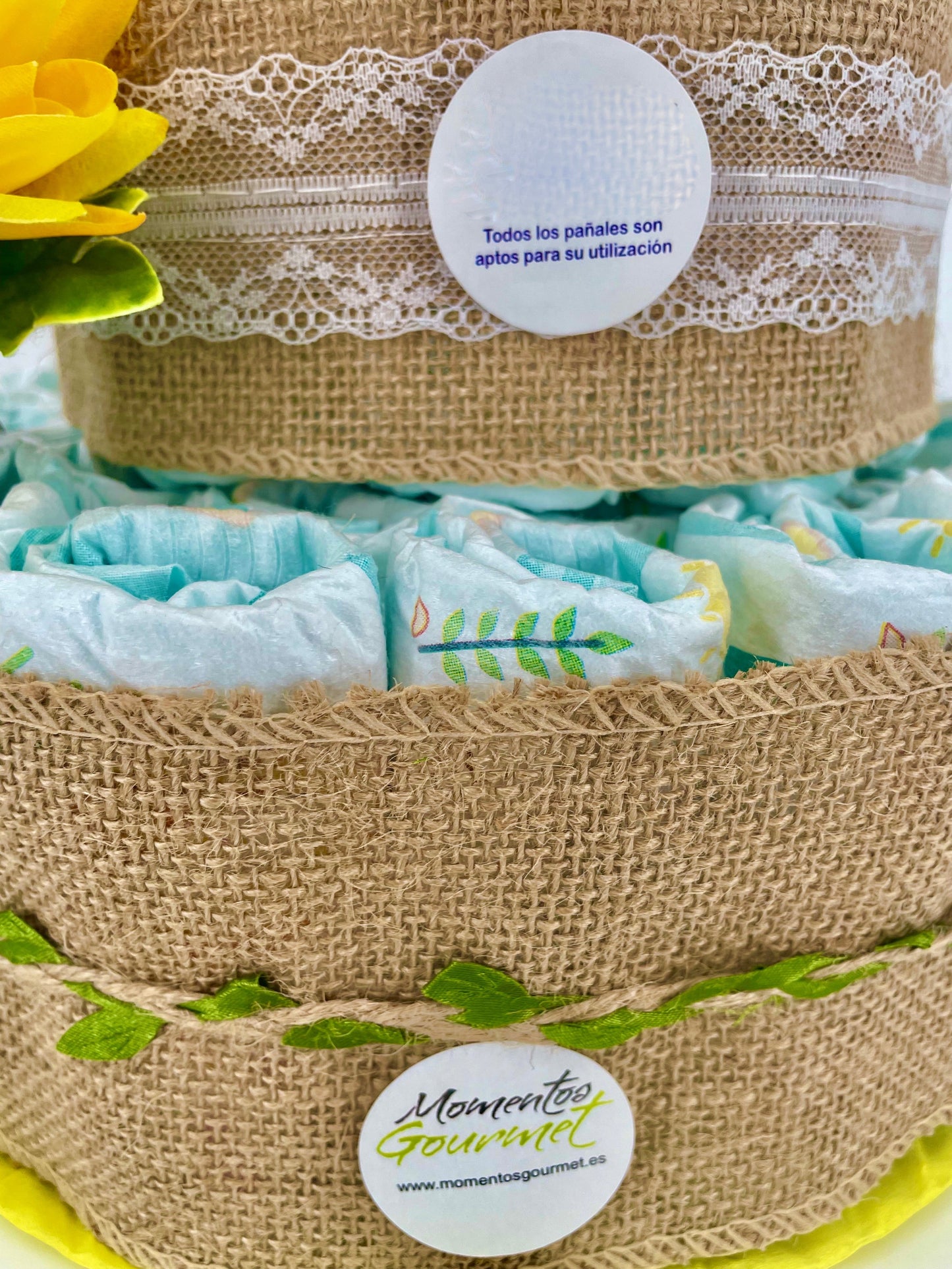 Tarta de pañales Summer de MomentosGourmet decorada con yute, encaje blanco y detalles florales para baby shower